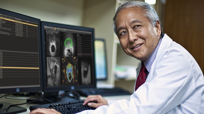 Male doctor sitting in front of screens
